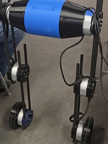 The real Adroit standing in the lab: a blue and black pod body on two wheeled legs